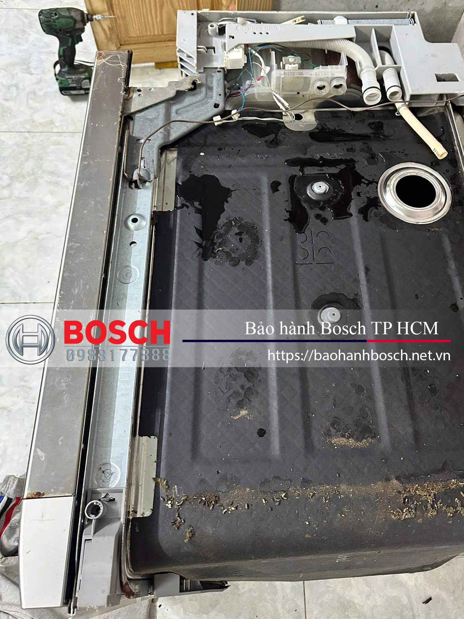 Đầu máy giặt Bosch bị mở ra để kiểm tra hoặc sửa chữa, với các linh kiện bên trong và phần khung máy. Hình ảnh thể hiện quá trình bảo hành hoặc bảo trì thiết bị Bosch tại TP HCM.