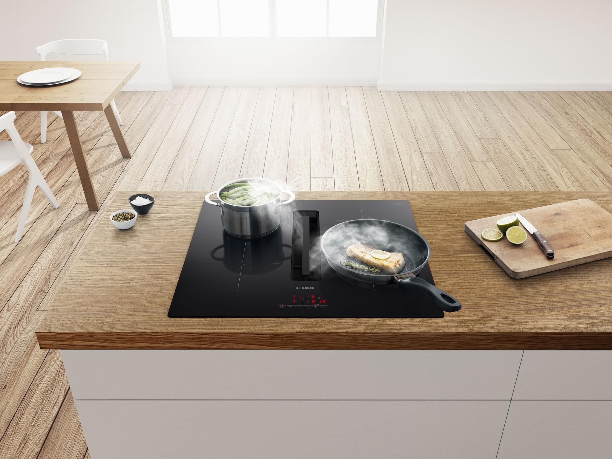 Nồi lẩu và chảo đang nấu trên bếp từ Bosch tại không gian bếp hiện đại, sang trọng. Bếp từ Bosch mang đến công nghệ tiên tiến, an toàn và tiết kiệm năng lượng, phù hợp cho căn bếp nhà bạn.